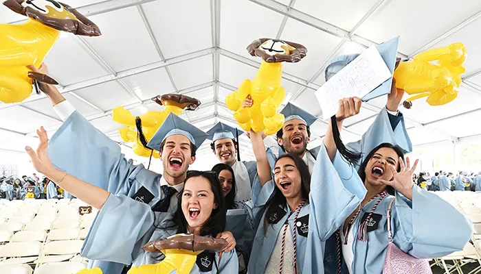 Columbia College graduates wave lions at a graduation ceremony.