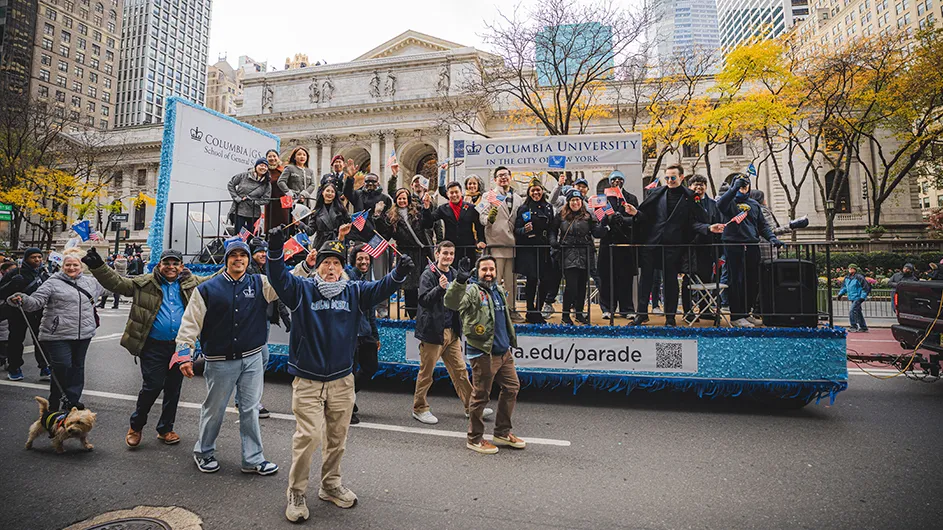 Columbians aboard and alongside the School of General Studies’ float in the New York City Veterans Day Parade, in front of the New York Public Library.