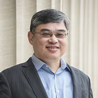Headshot of Columbia Trustee Fermi Wang: Man with glasses in a dark suit with a light blue shirt